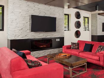 A living room with a red couch and a fireplace at Skye at Belltown Apartments, Seattle, WA 98121
